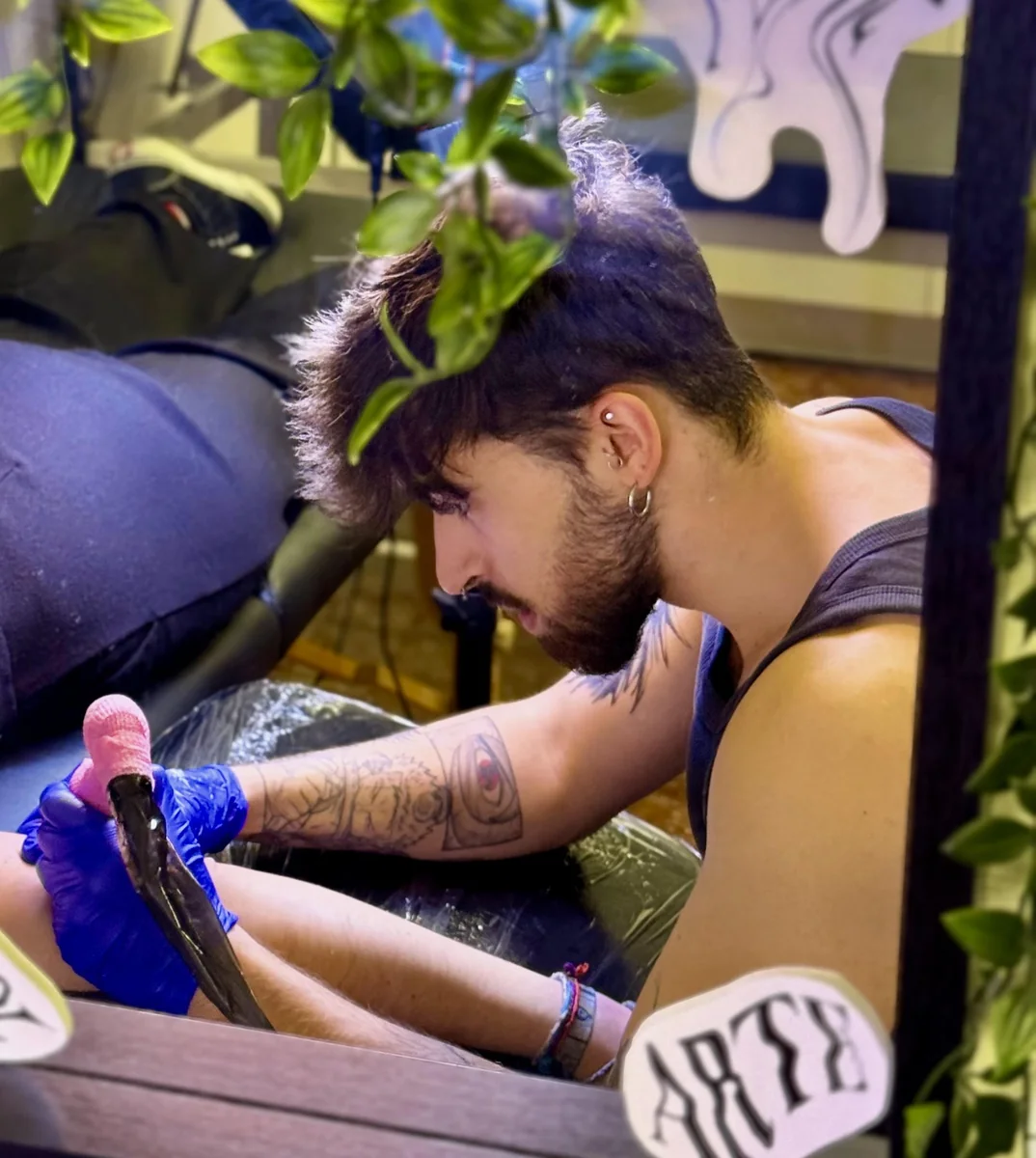 CURE tatuando a un cliente en su estudio